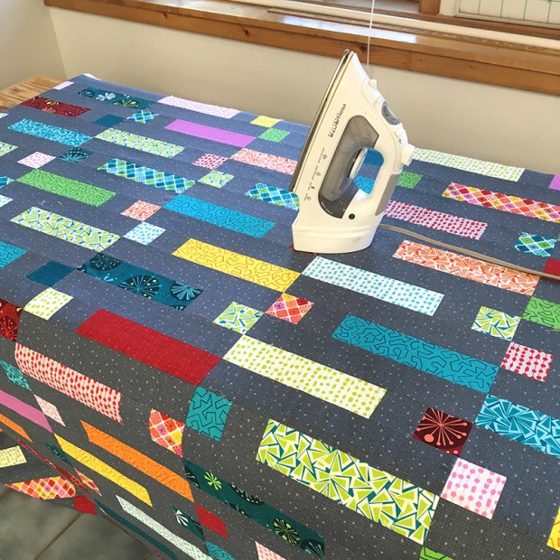 Iron the basted quilt to set the glue