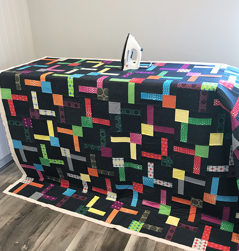 Iron the basted quilt to set the glue